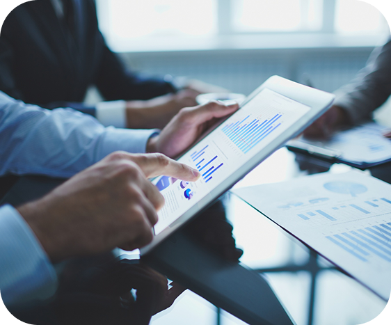 Executivo analisando gráficos financeiros em tablet durante reunião de consultoria.